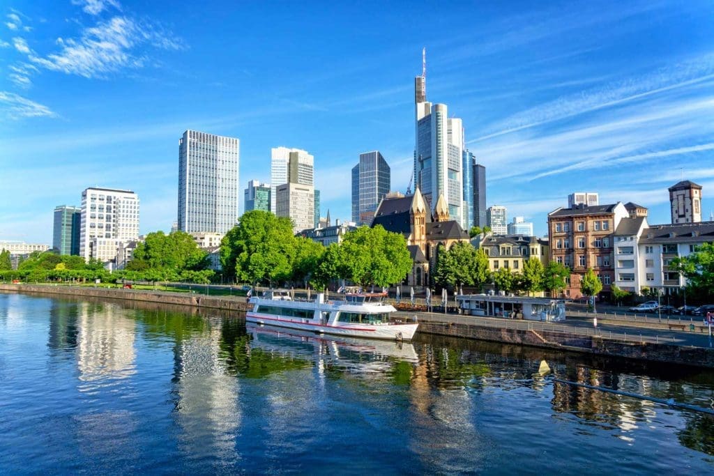 Frankfurt skyline viewed from the River Main with office towers, riverside buildings and a passenger boat.